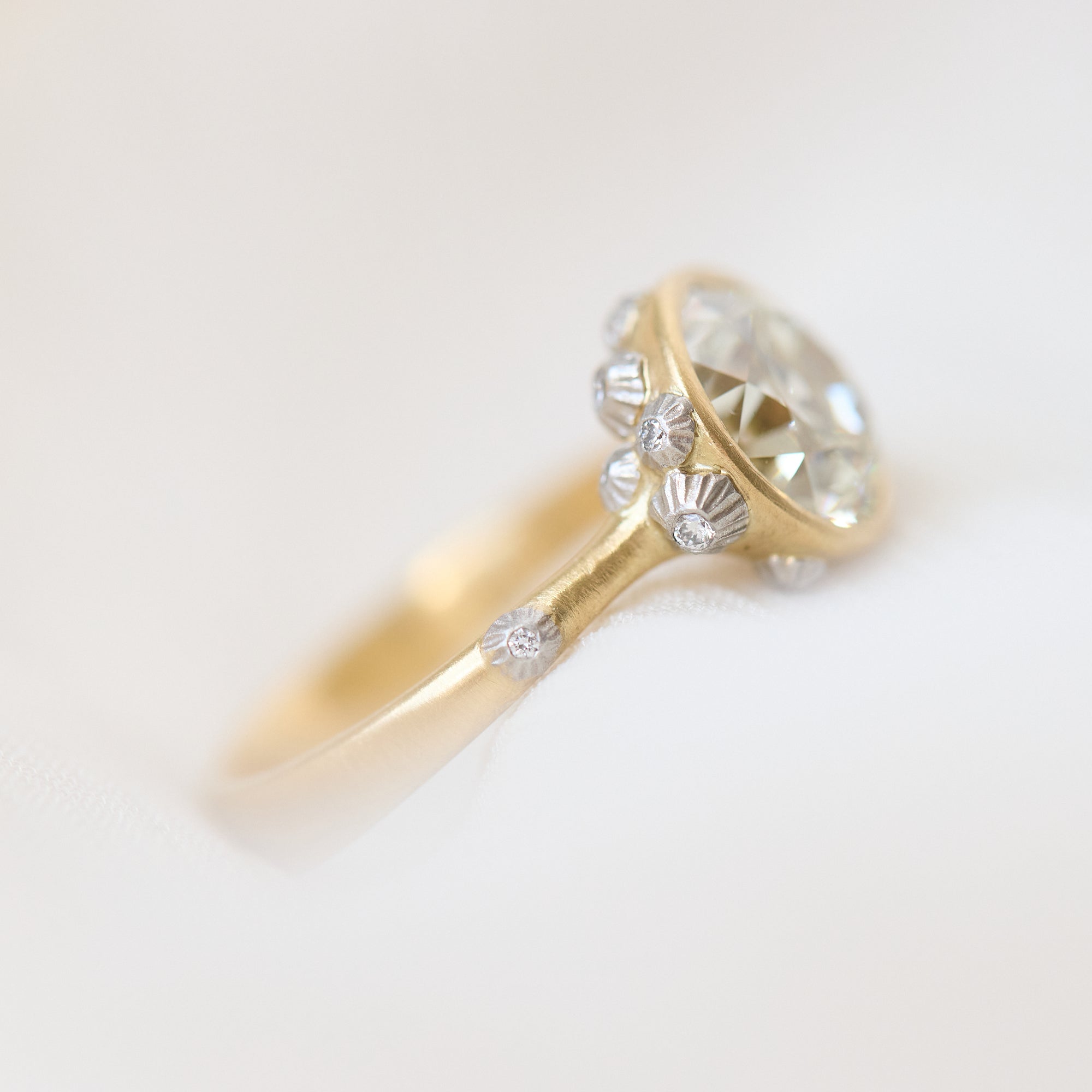 Gold ring with a diamond on a light gray background