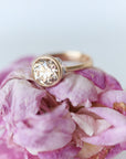 Gold ring with a large diamond on pink floral petals