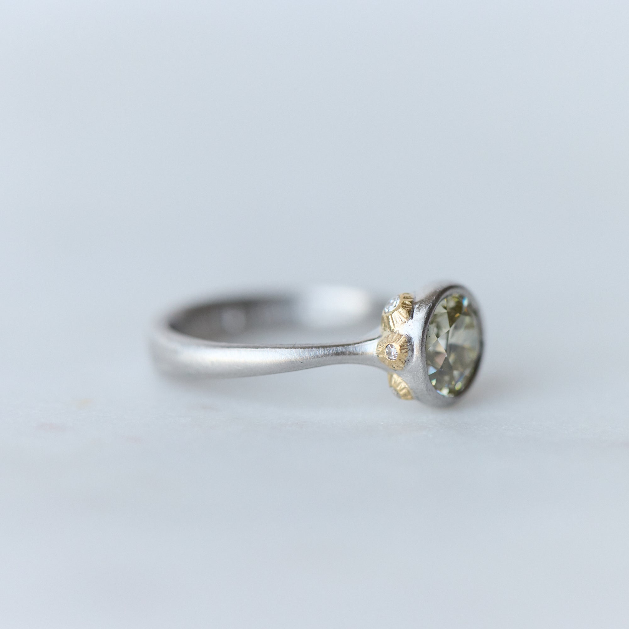 Silver ring with a gemstone on a light gray background