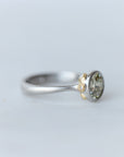 Silver ring with a gemstone on a light gray background