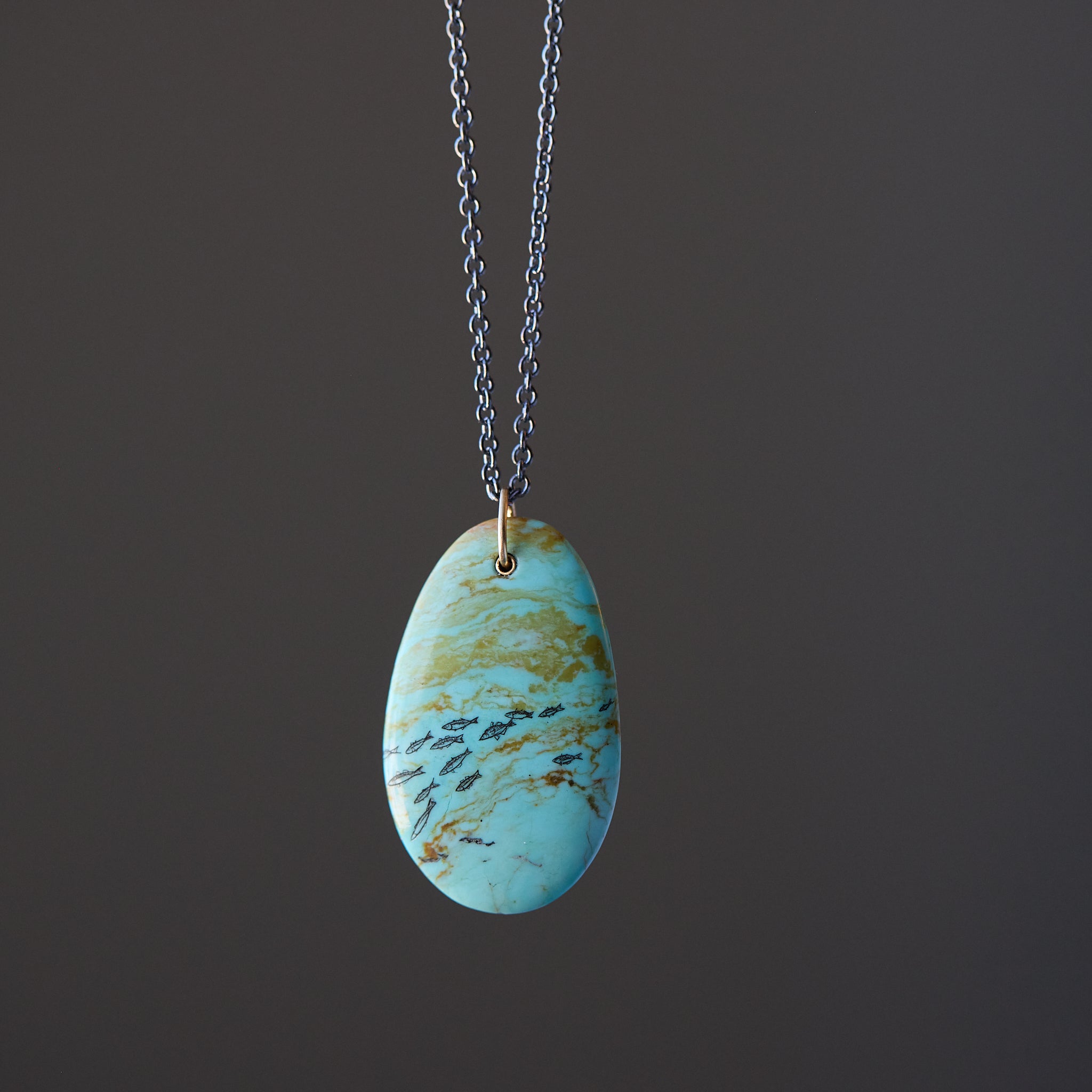 Necklace with a turquoise pendant on a dark background