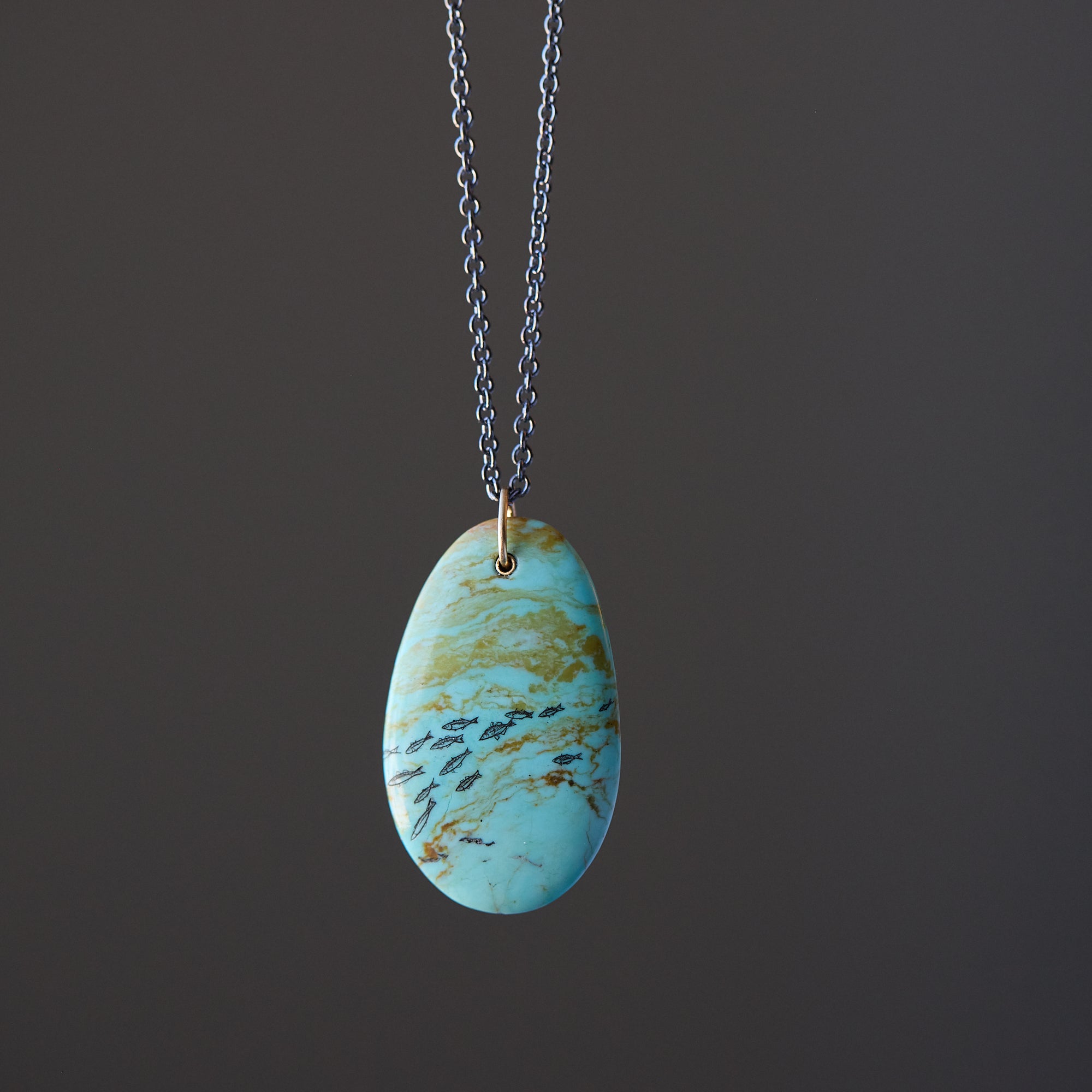Necklace with a turquoise pendant on a dark background