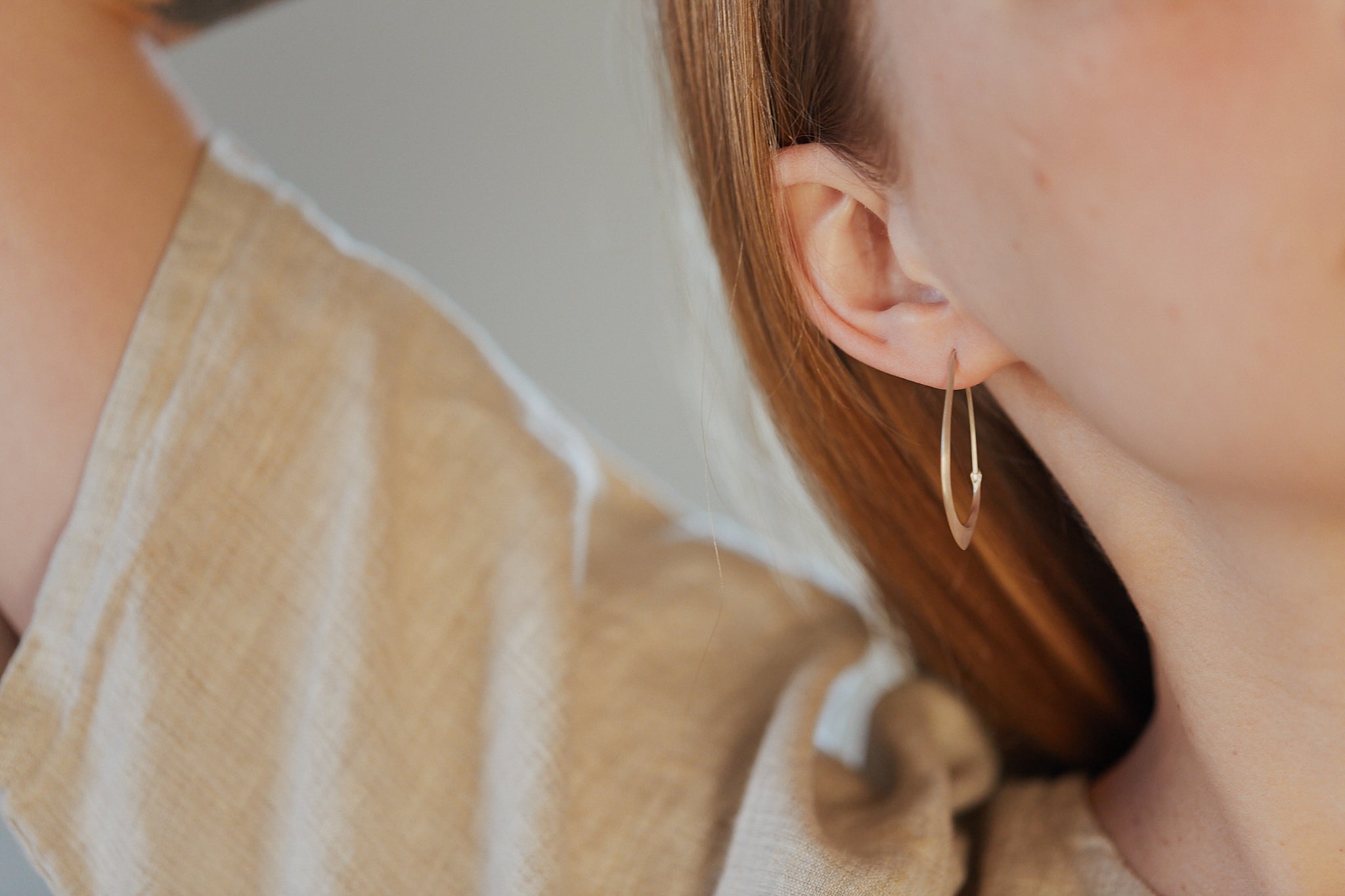 small facet hoops in gold shown on person