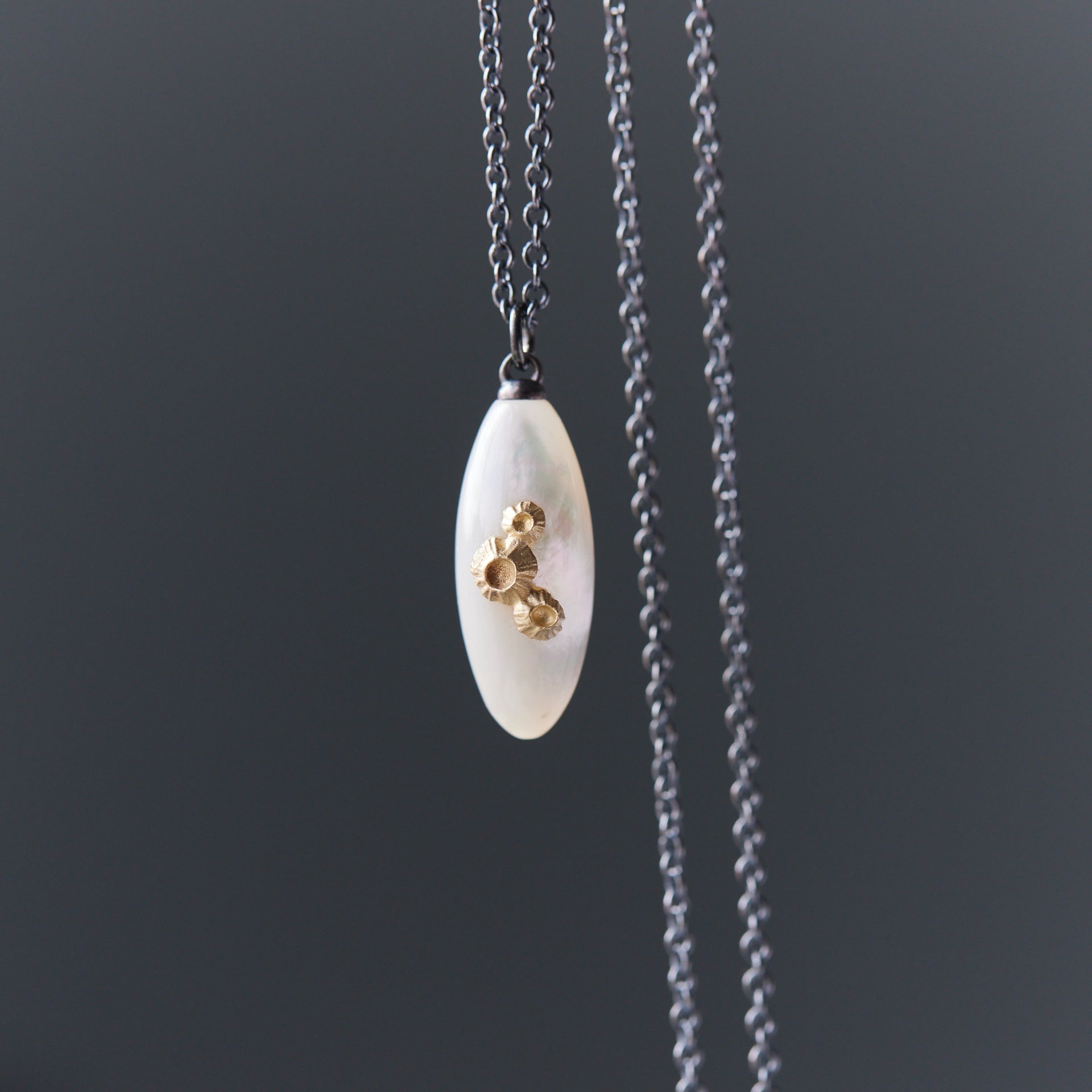 medium sized mother of pearl pendant necklace in oxidized silver with 14k gold barnacles