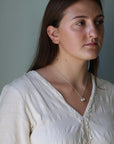 Woman wearing a white blouse against a gray background
