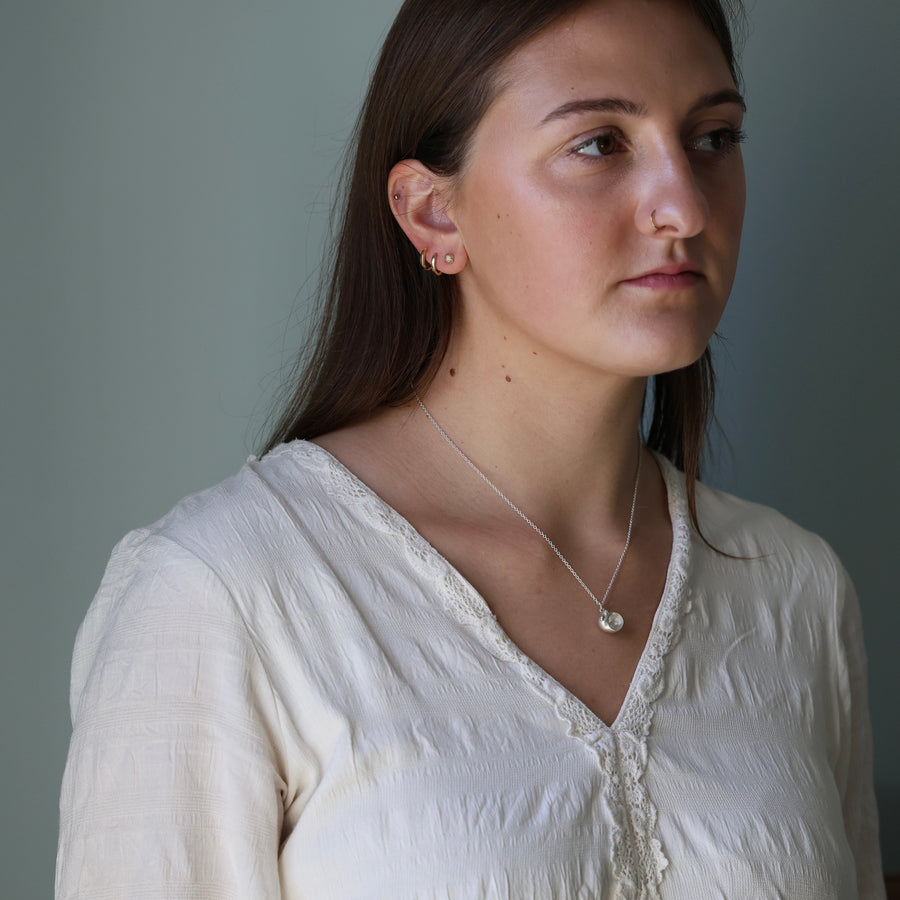 Woman wearing a white blouse against a gray background
