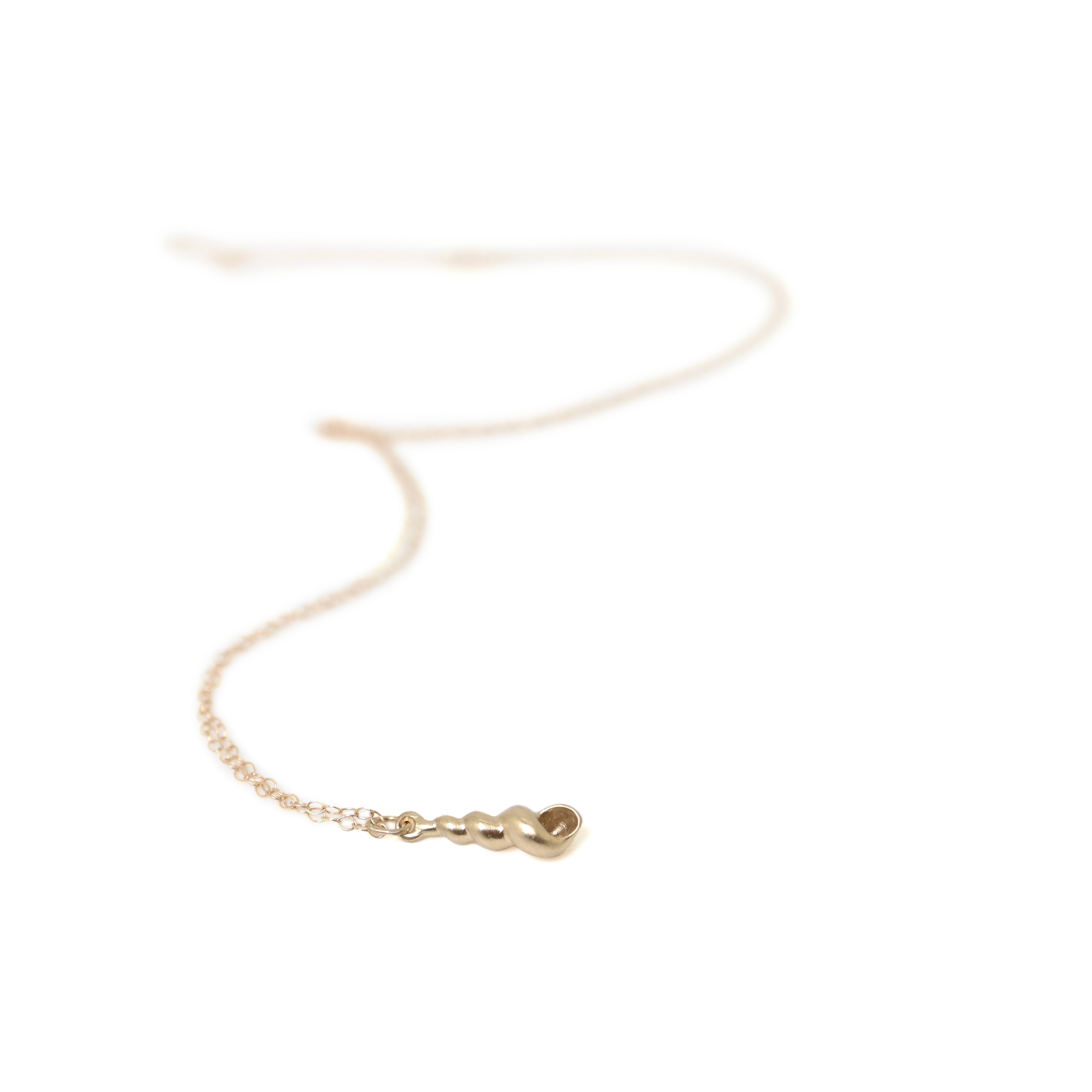 Tiny handcarved turret shell in gold by Hannah Blount