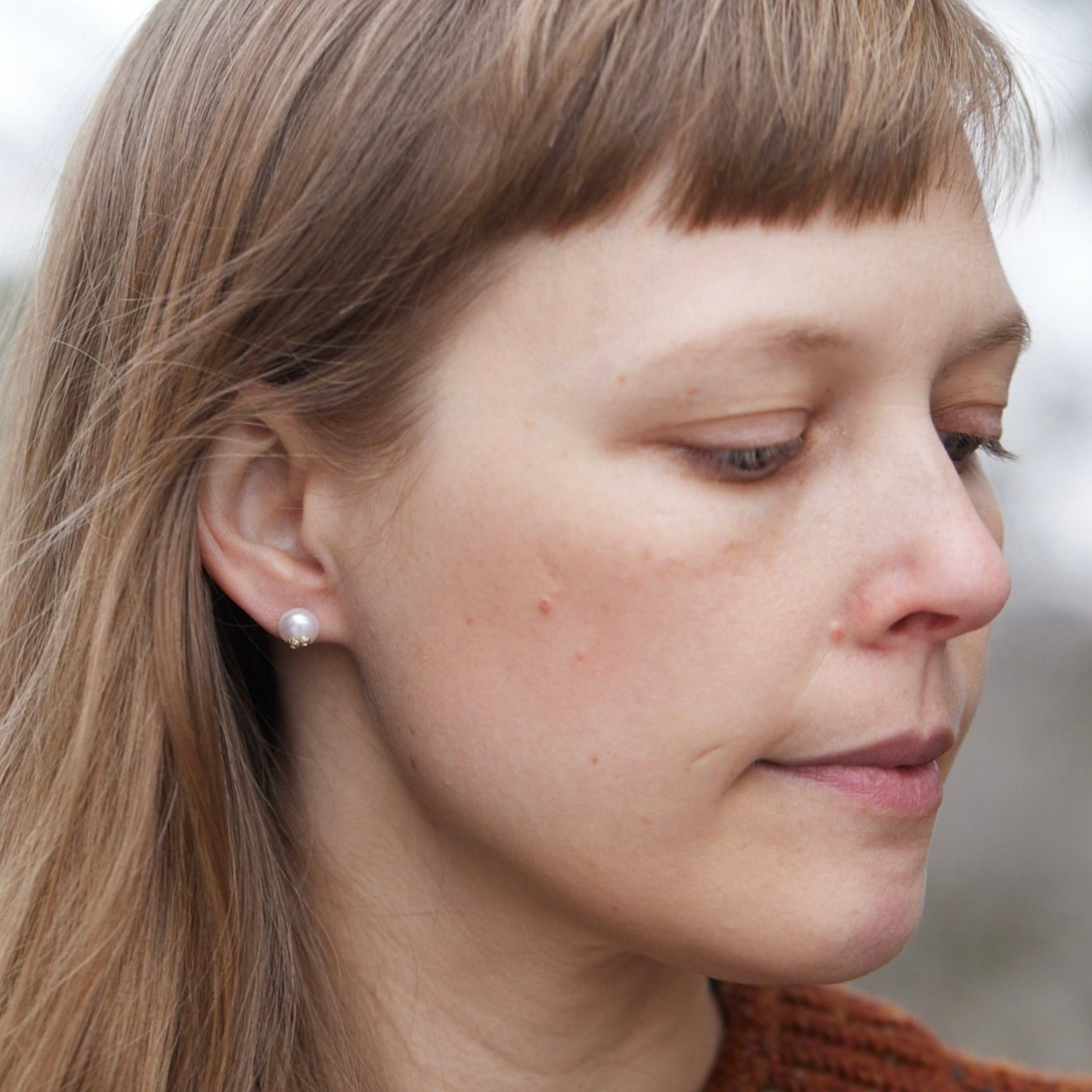 Little pearl studs with gold barnacles, photographed on person.