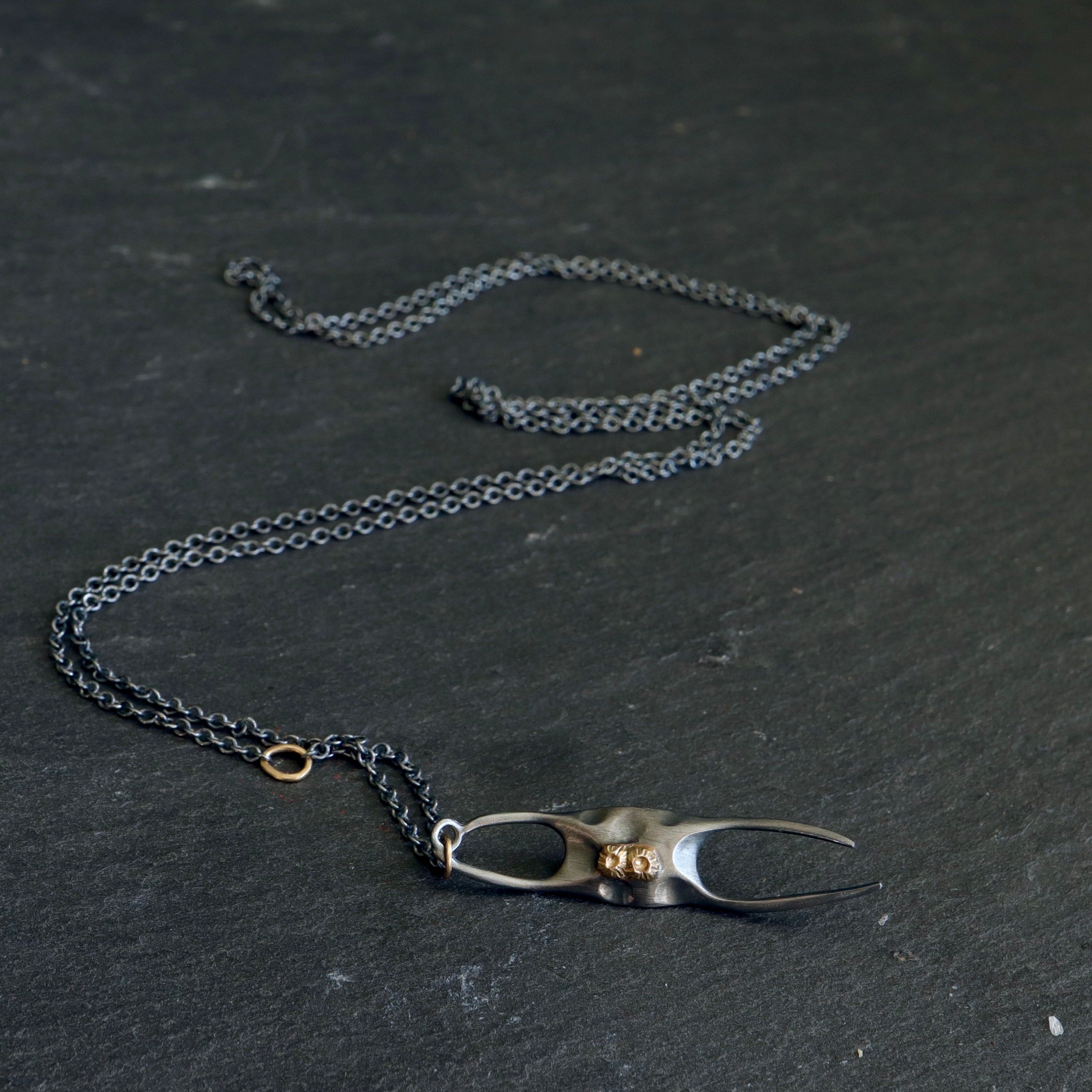 medium oxidized silver skate egg case pendant with gold barnacles and gold egg link on black chain