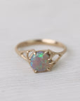 Colorful opal in delicate gold prongs on a white background
