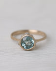 gold ring with light blue stone on white background