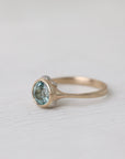 gold ring with light blue stone on white background