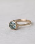 gold ring with light blue stone on white background