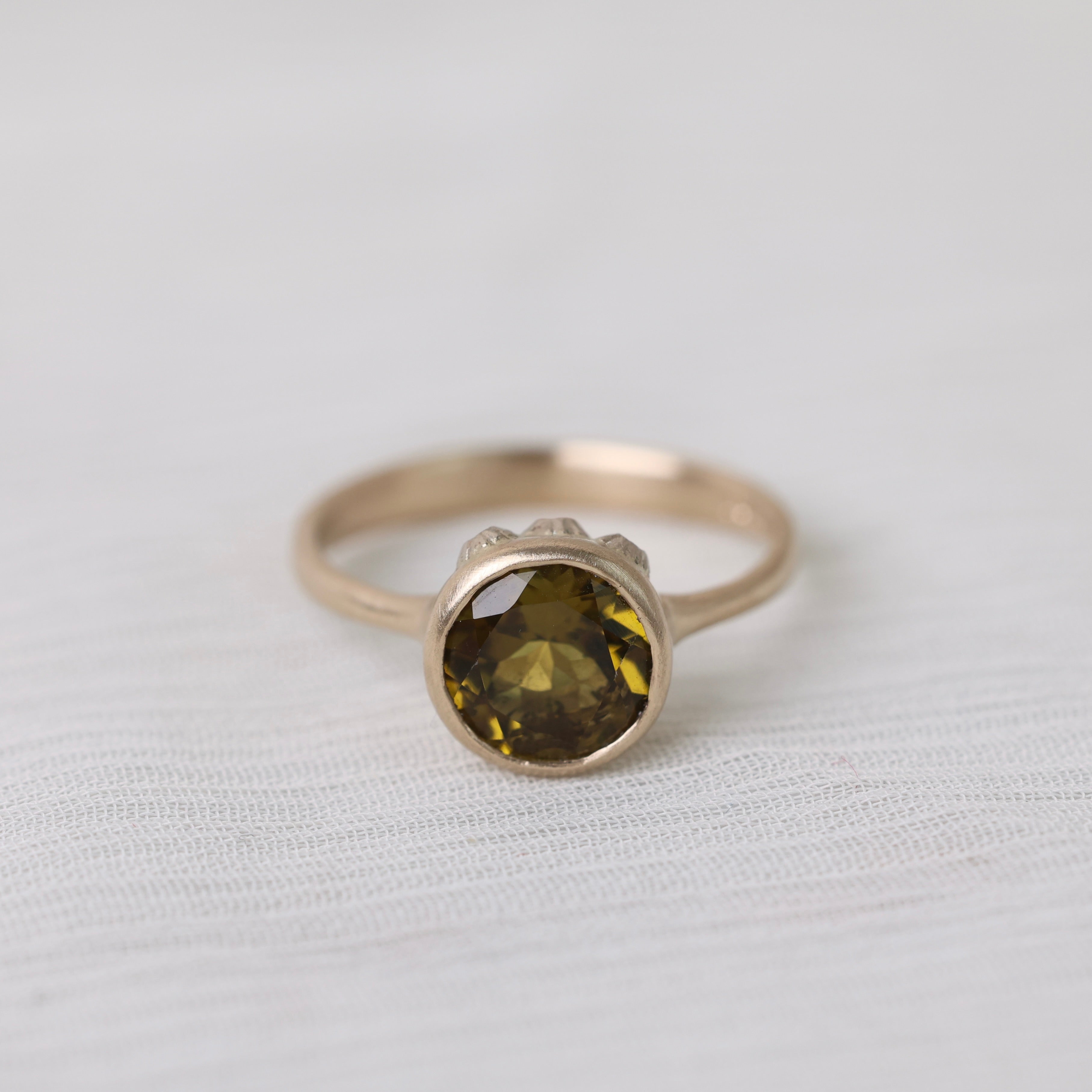 Olive green stone gold ring on white background