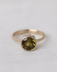 Olive green stone gold ring on white background
