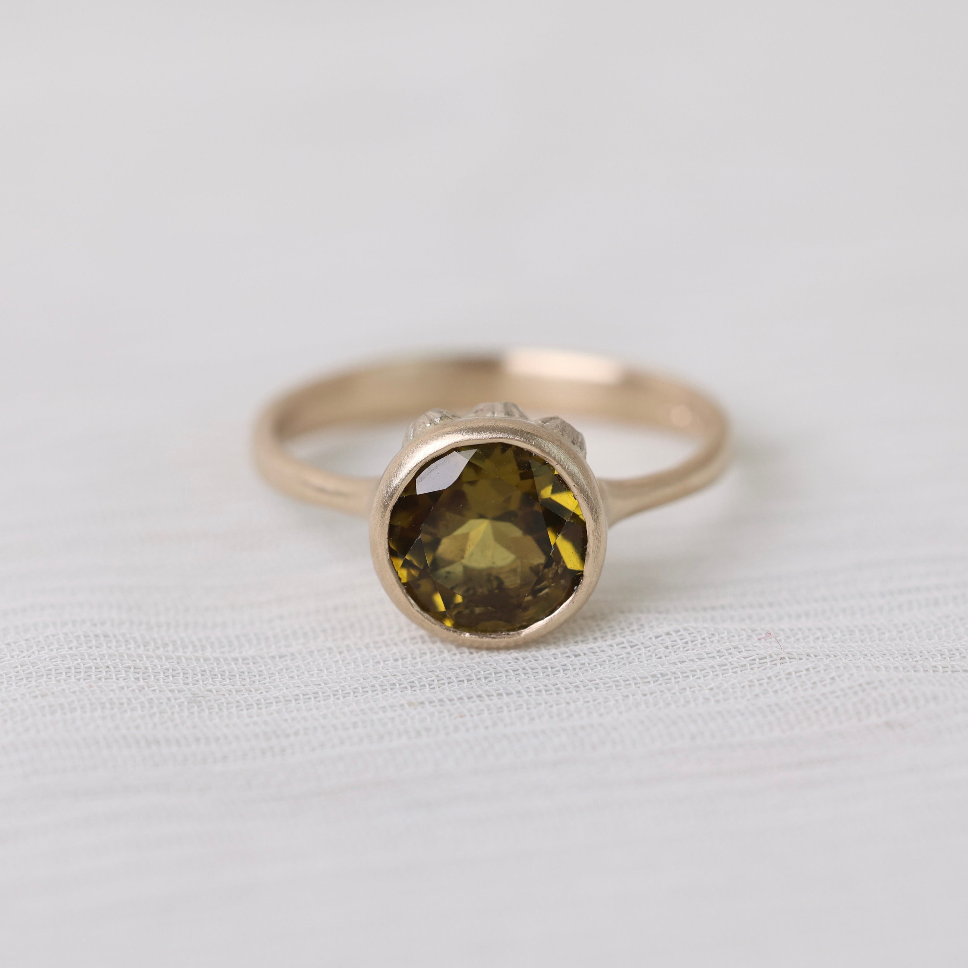 Olive green stone gold ring on white background