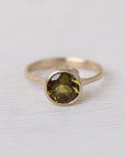 Olive green stone gold ring on white background