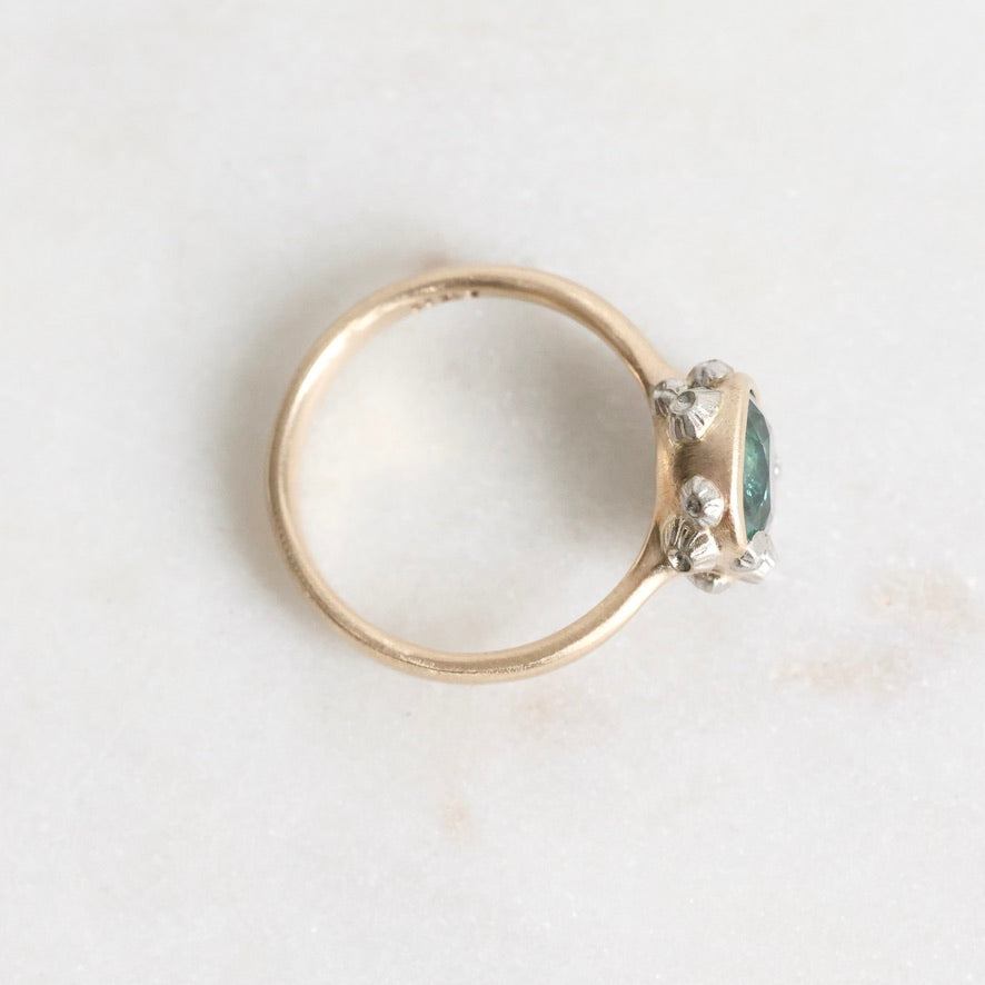 Gold ring with a gemstone on a light gray background