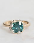 Ring with a blue gemstone and silver accents on a light gray background