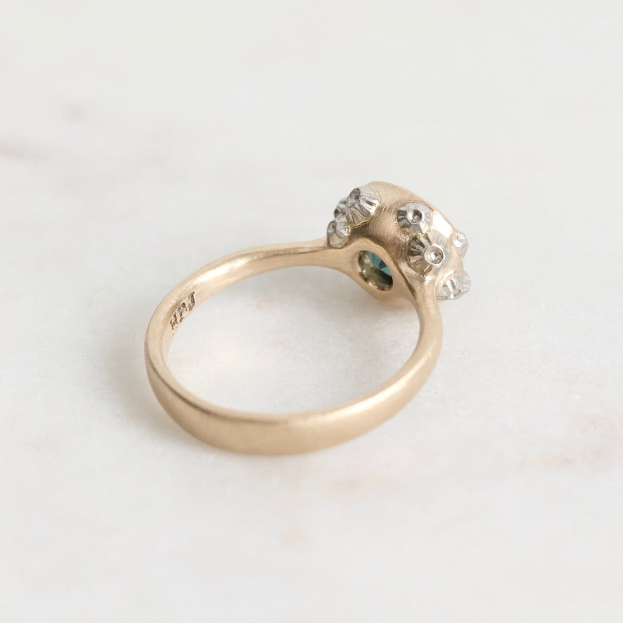 Gold ring with a diamond on a light gray background