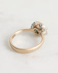 Gold ring with a diamond on a light gray background