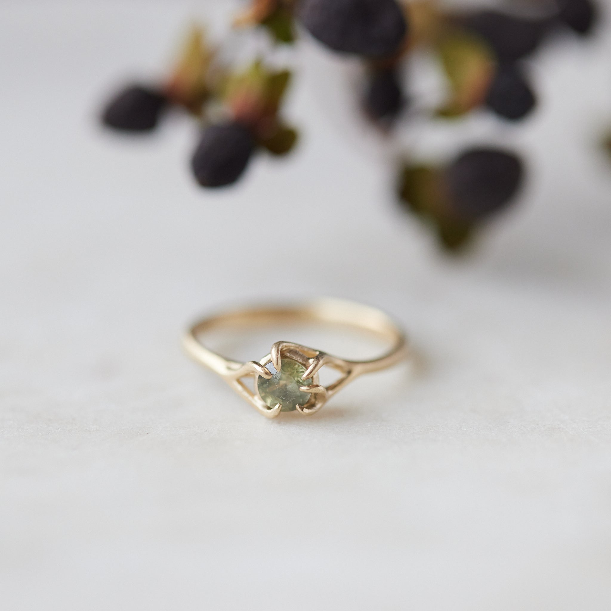 round sage green montana sapphire set in a gold ring with branching prongs