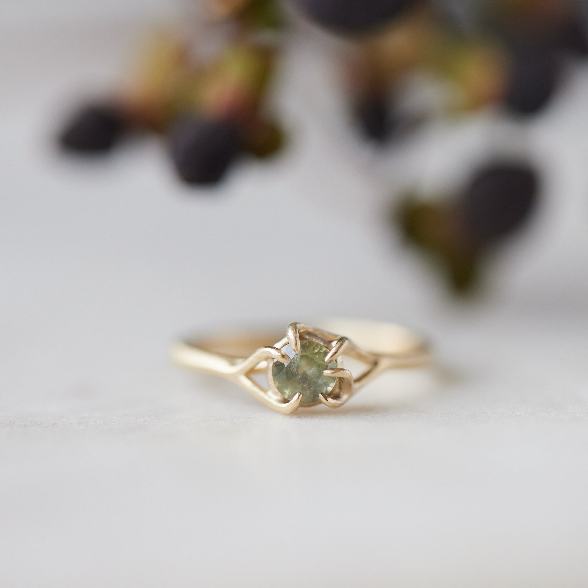 round sage green montana sapphire set in a gold ring with branching prongs