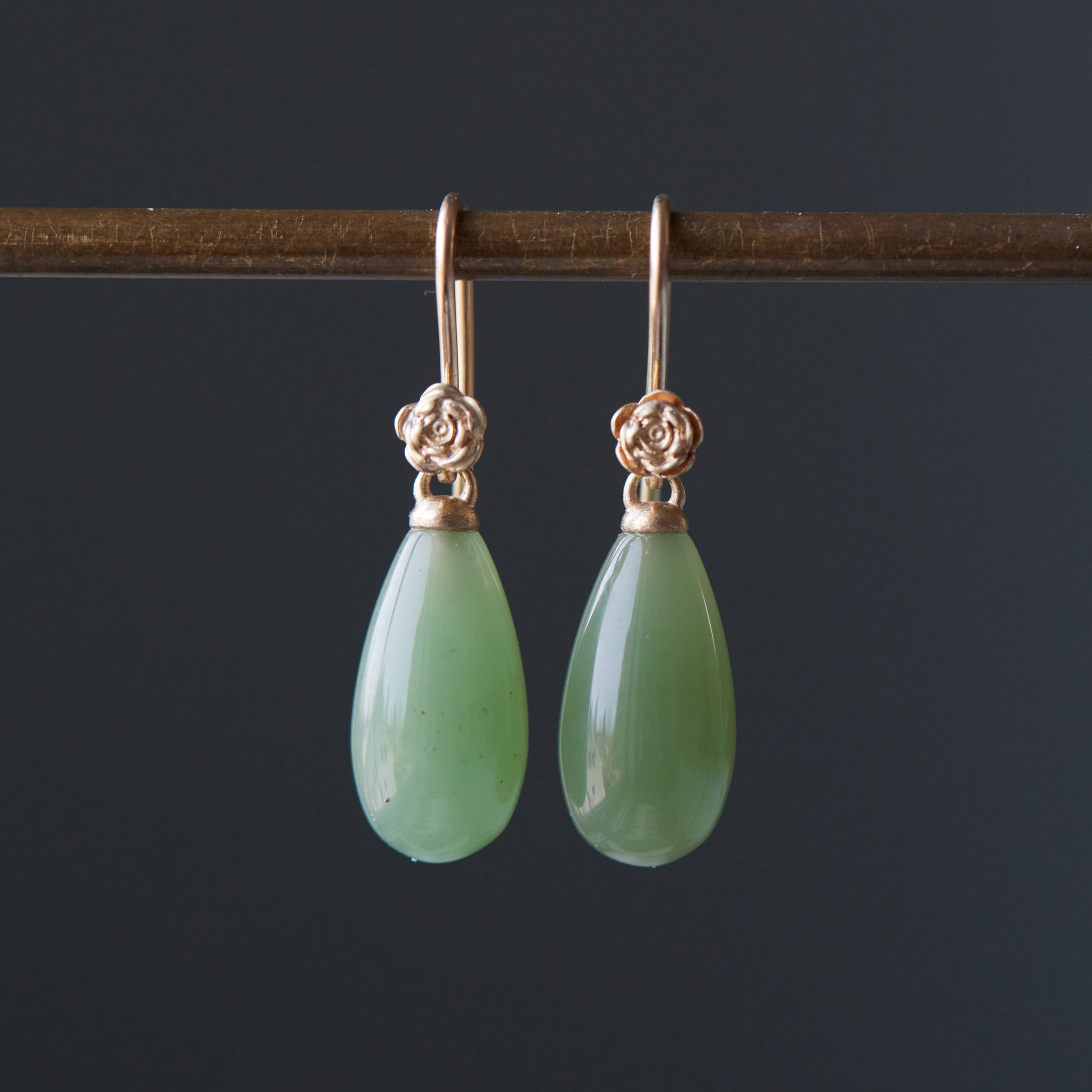 sage green nephrite jade teardrops hang beneath gold rose ear wires