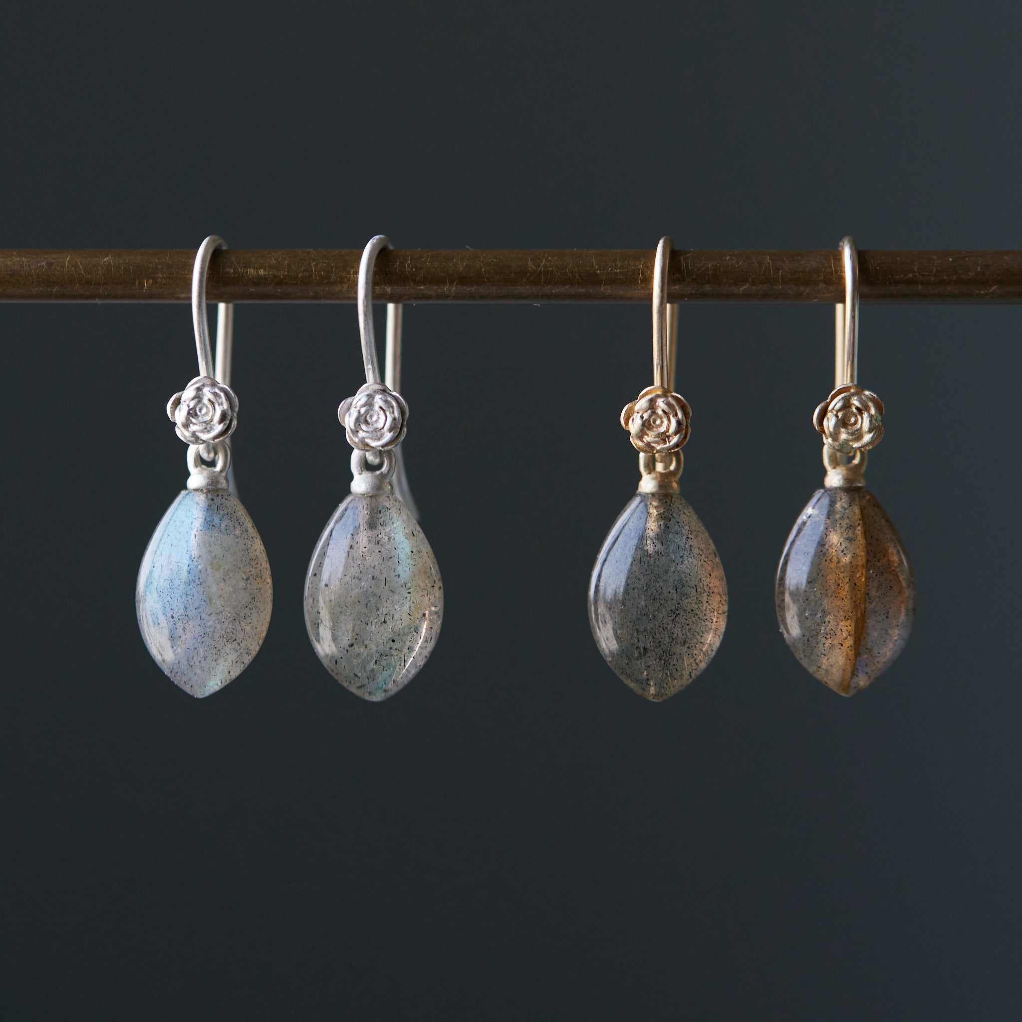 flashing with blue, grey labradorite cones hang beneath gold and silver ear wires and roses. 