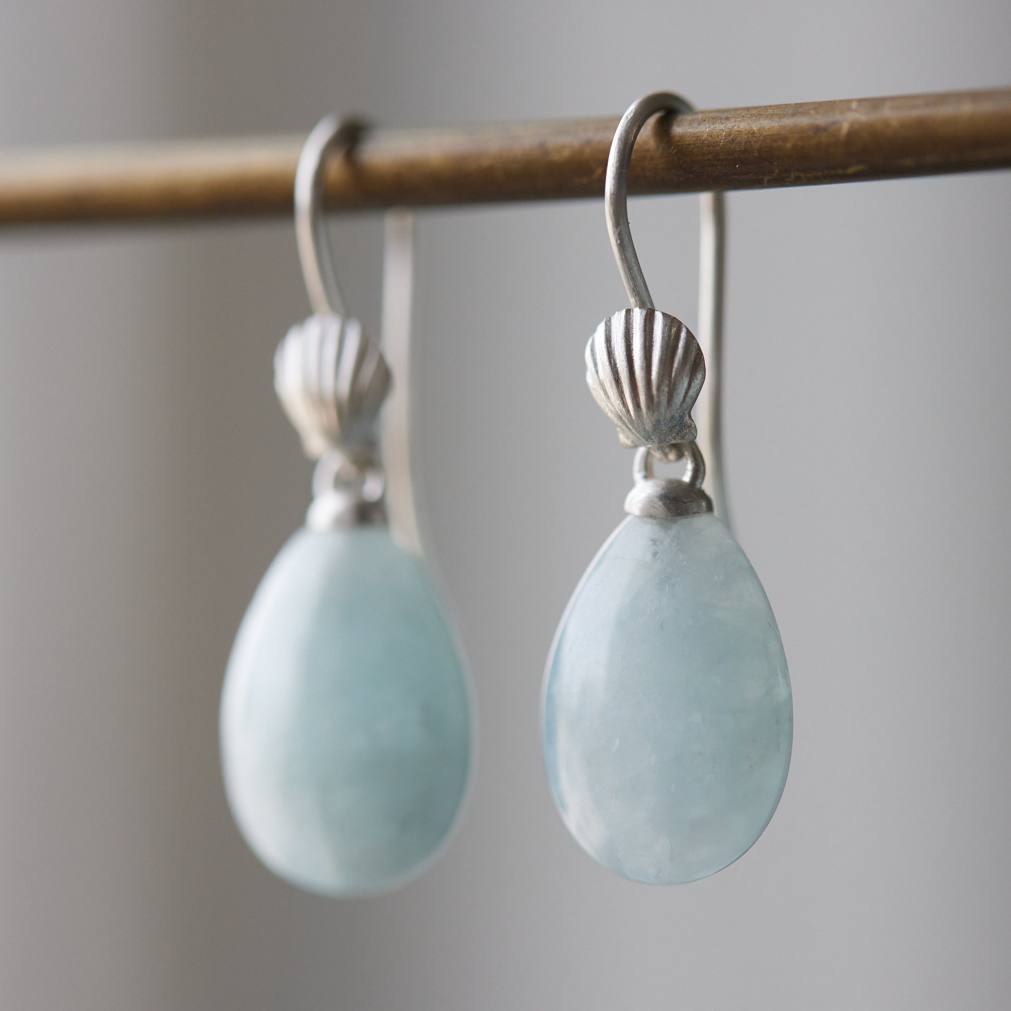 teardrops of pale, icy aquamarine hang beneath little silver scallop shell ear wires