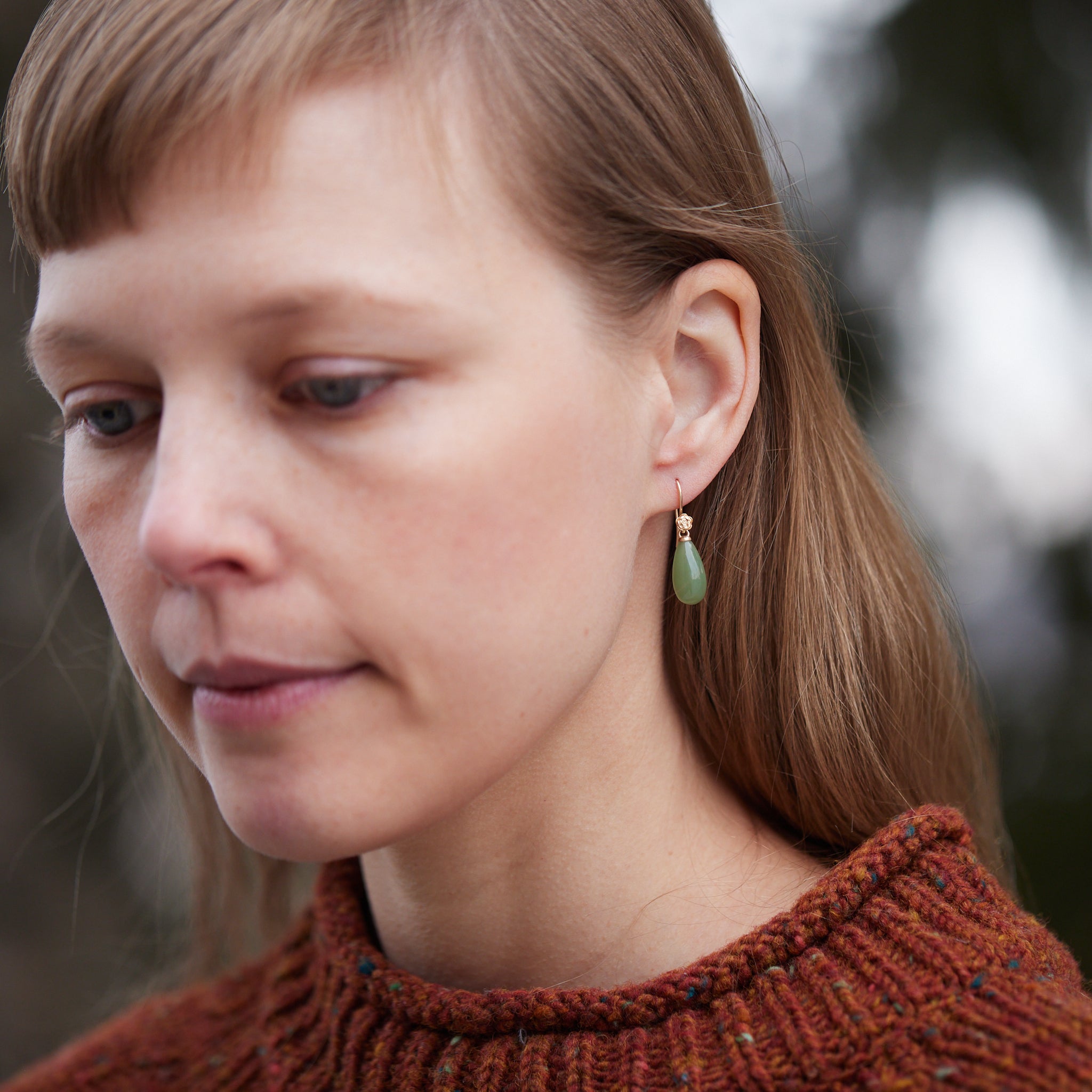 sage green nephrite jade teardrops hang beneath gold rose ear wires