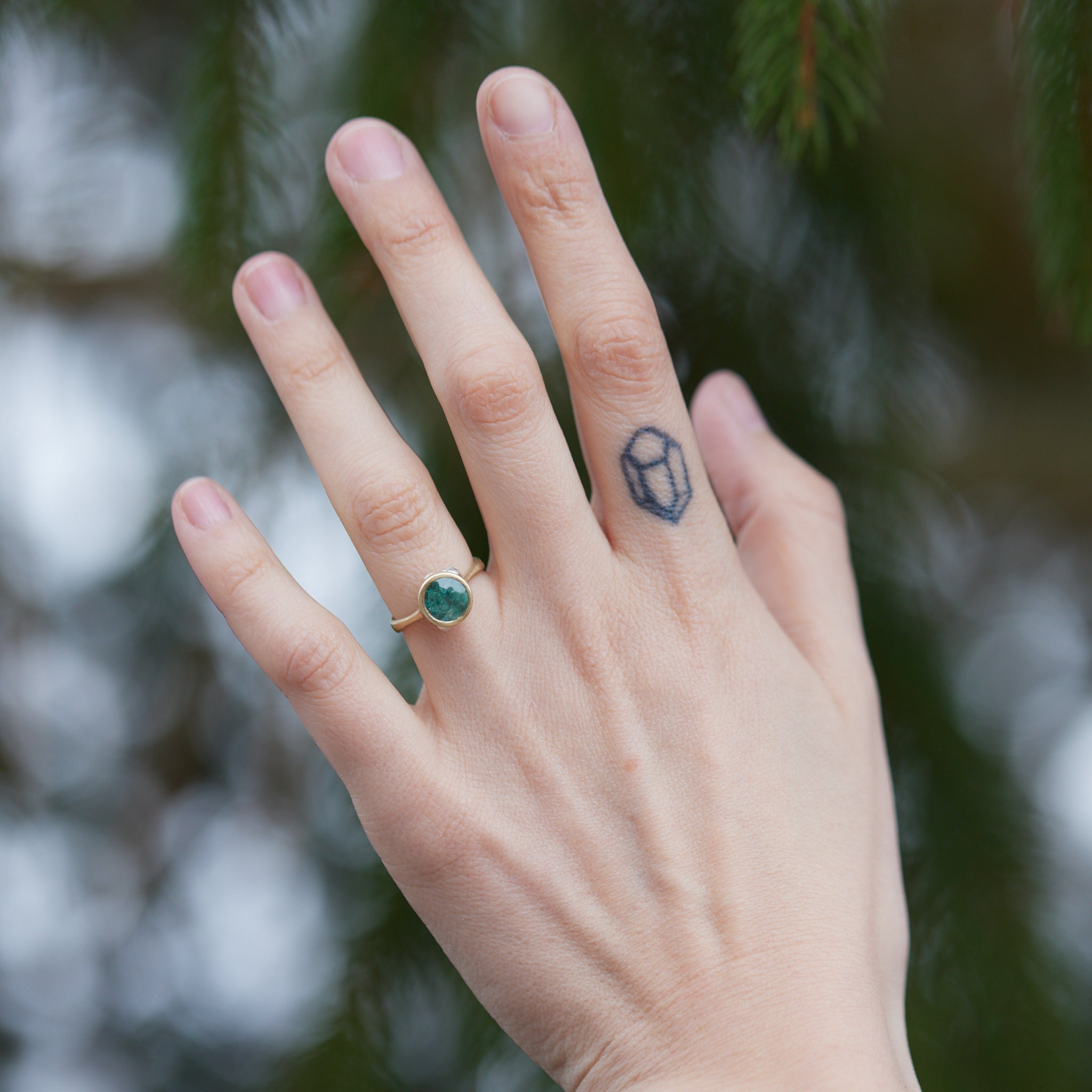 Tourmaline in yellow gold bezel setting with hand-carved barnacles on person