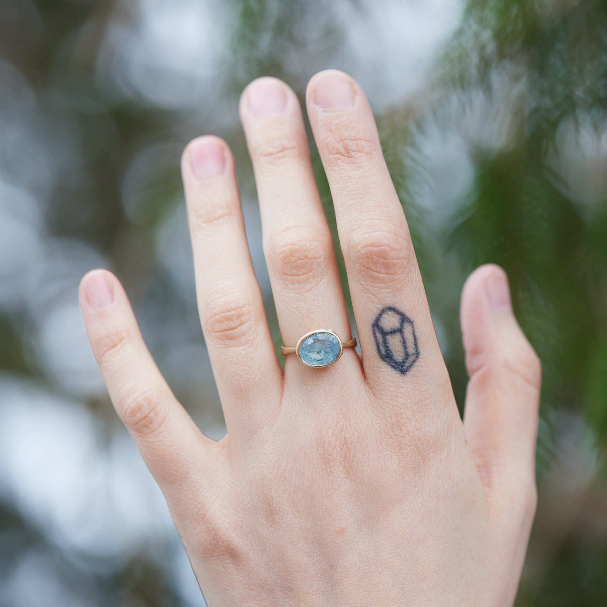 Aquamarine gold bezel ring with barnacles on hand