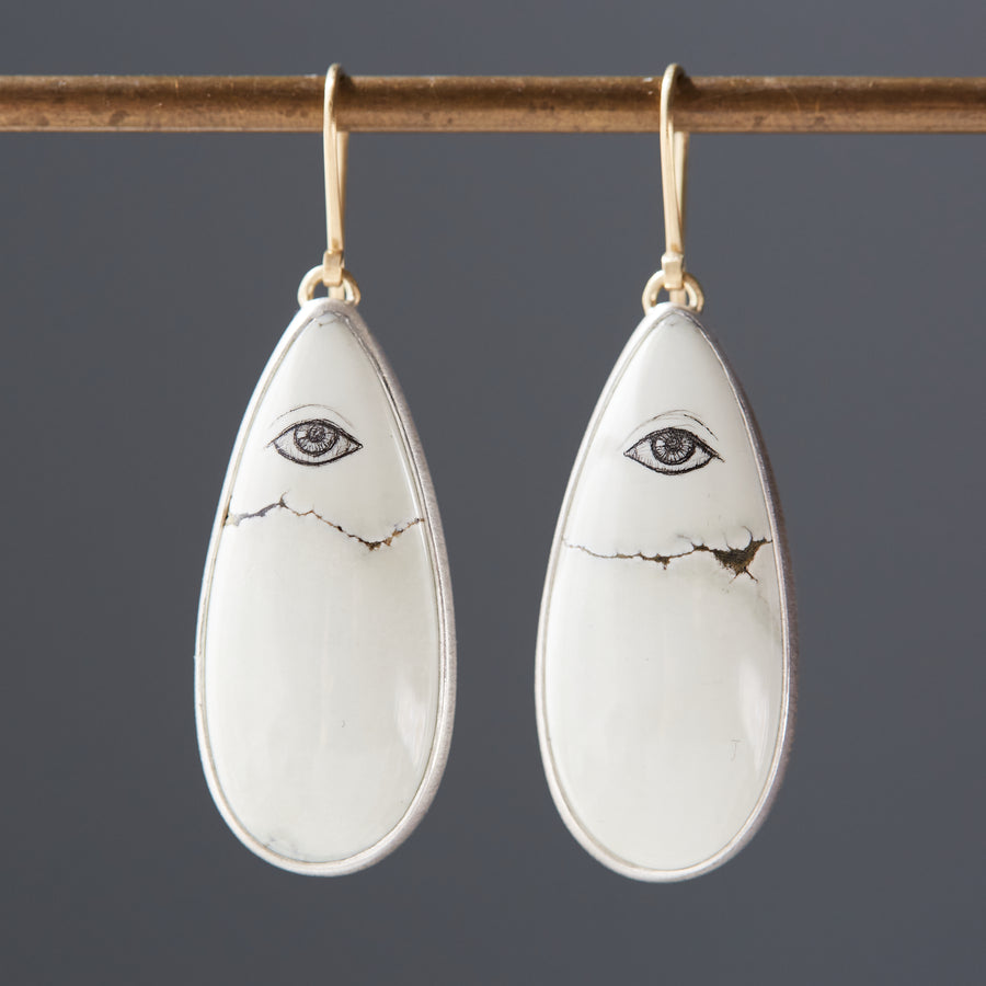 Scrimshaw Variscite Lover's Eye earrings hanging on bar