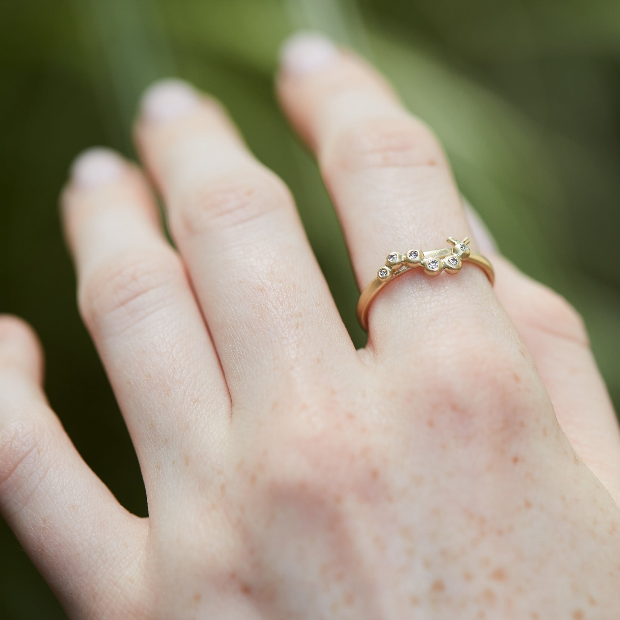 Caterpillar and diamond 14k gold ring on hand by hannah blount jewelry