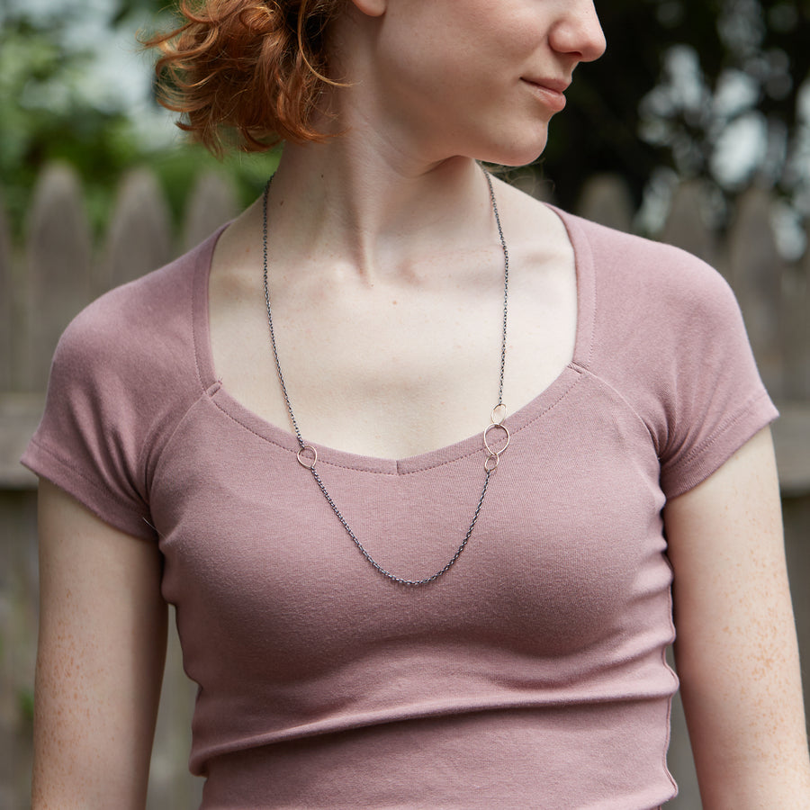Silver and gold egg link necklace on person- Hannah Blount