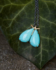 kingman turquoise longtail moth necklace with prongs on leaf by hannah blount jewelry