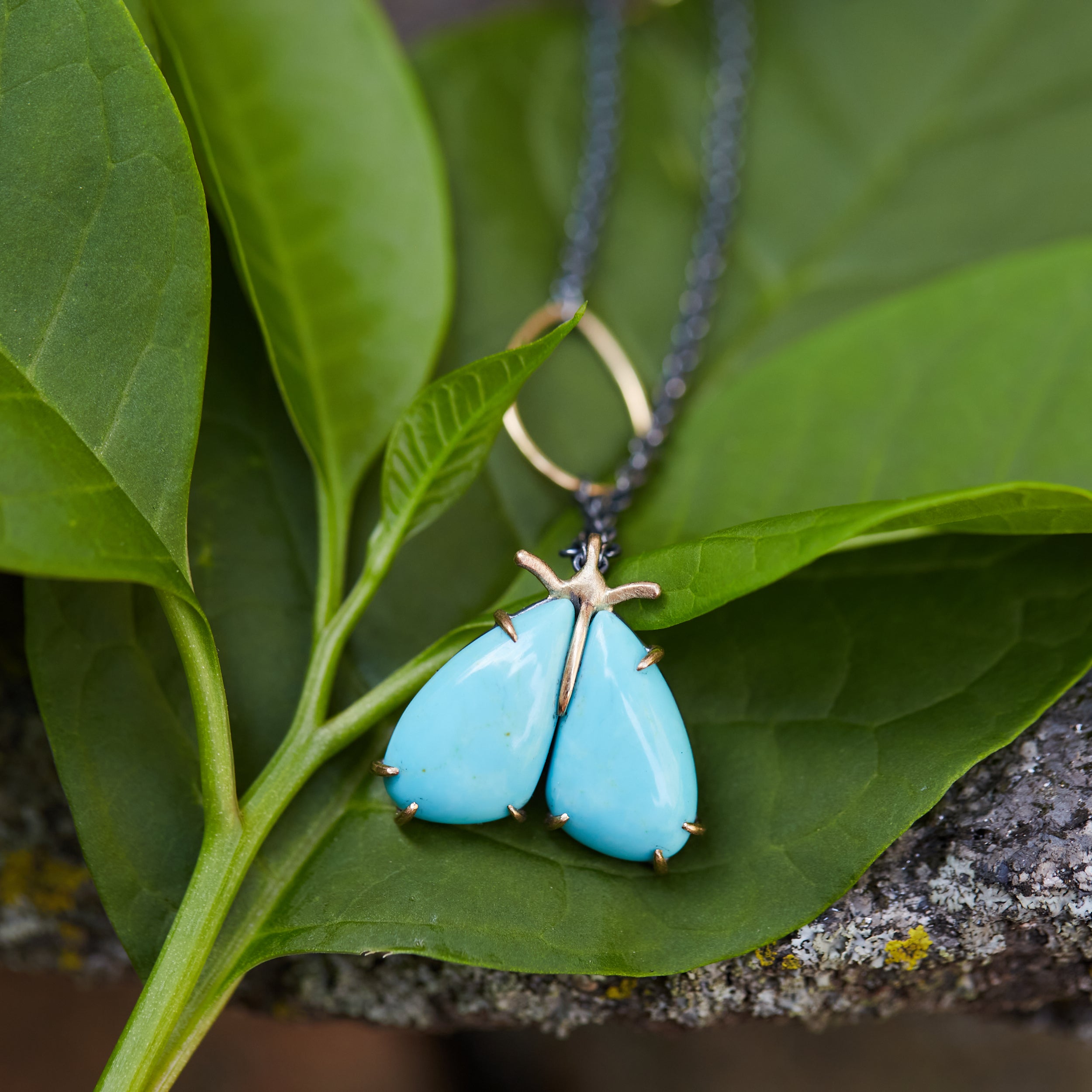 kingman turquoise longtail moth necklace with prongs on leaf by hannah blount jewelry