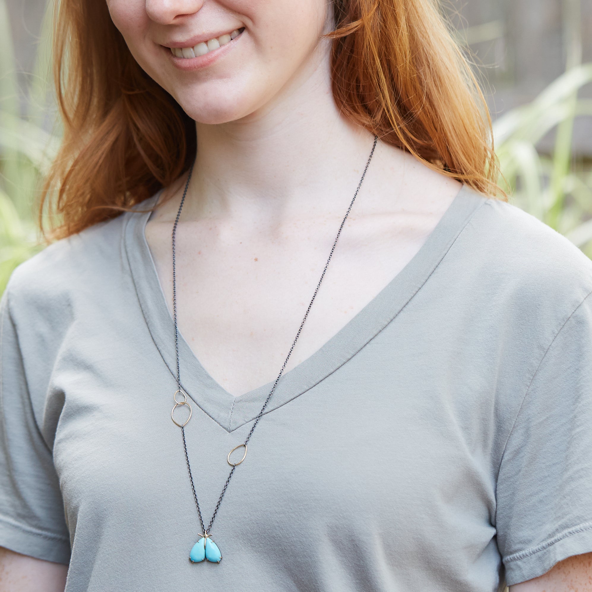 kingman turquoise longtail moth necklace with prongs on person by hannah blount jewelry