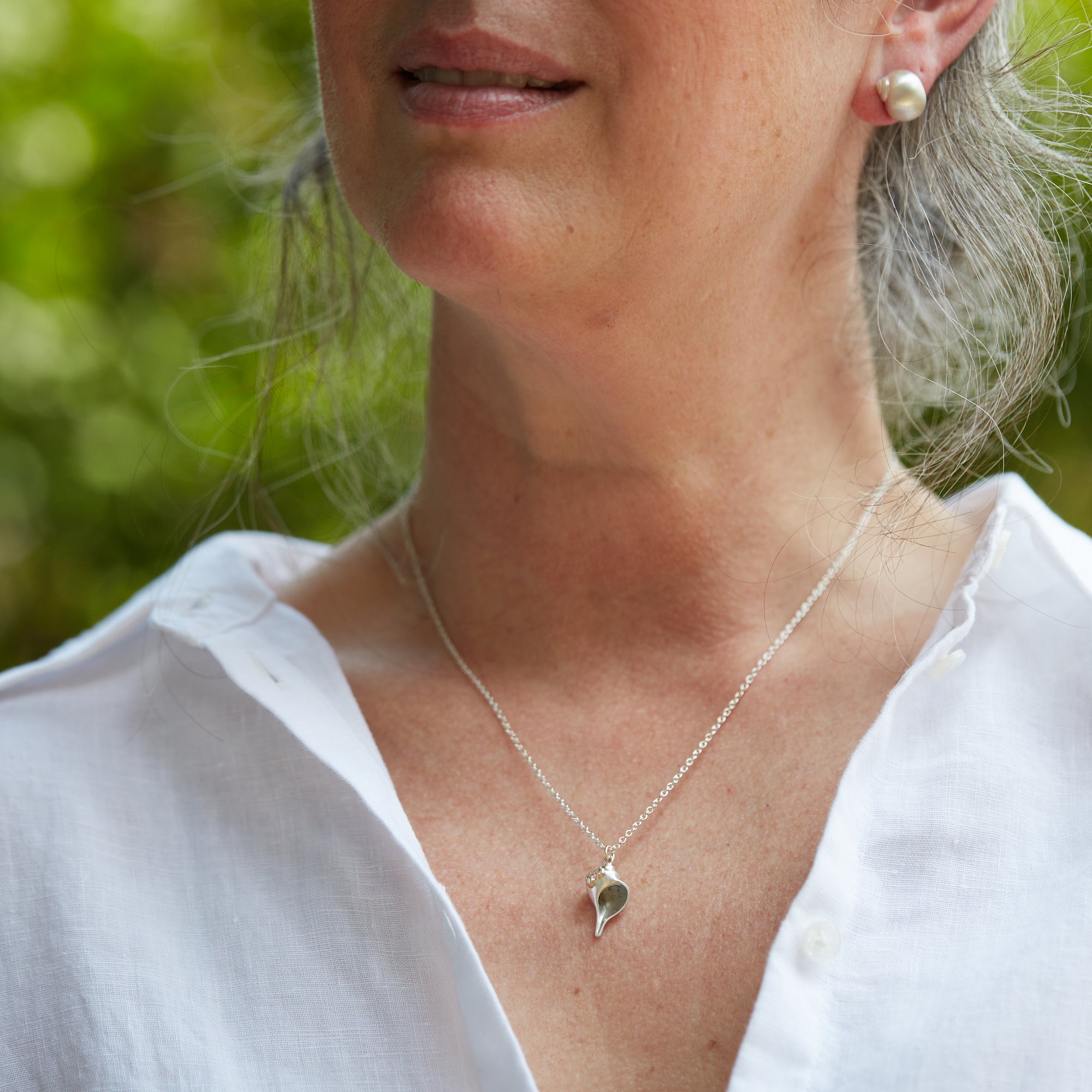 Whelk shell necklace with diamond barnacles on person
