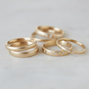 Ovoid gold bands with and without diamonds by Hannah Blount