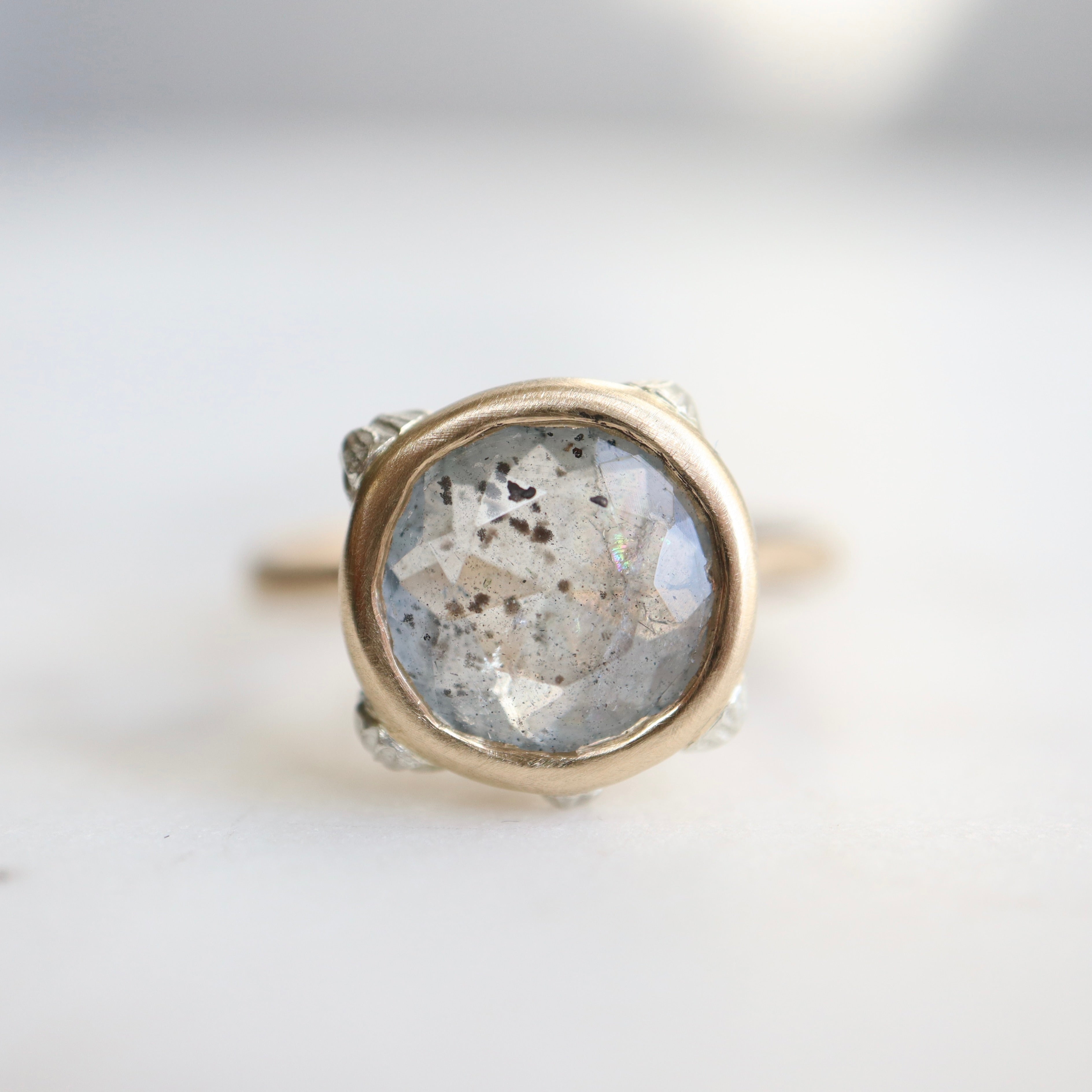 A 2.1ct Aquamarine ring with black inclusions set in a 10k gold band encrusted with silver barnacles. 