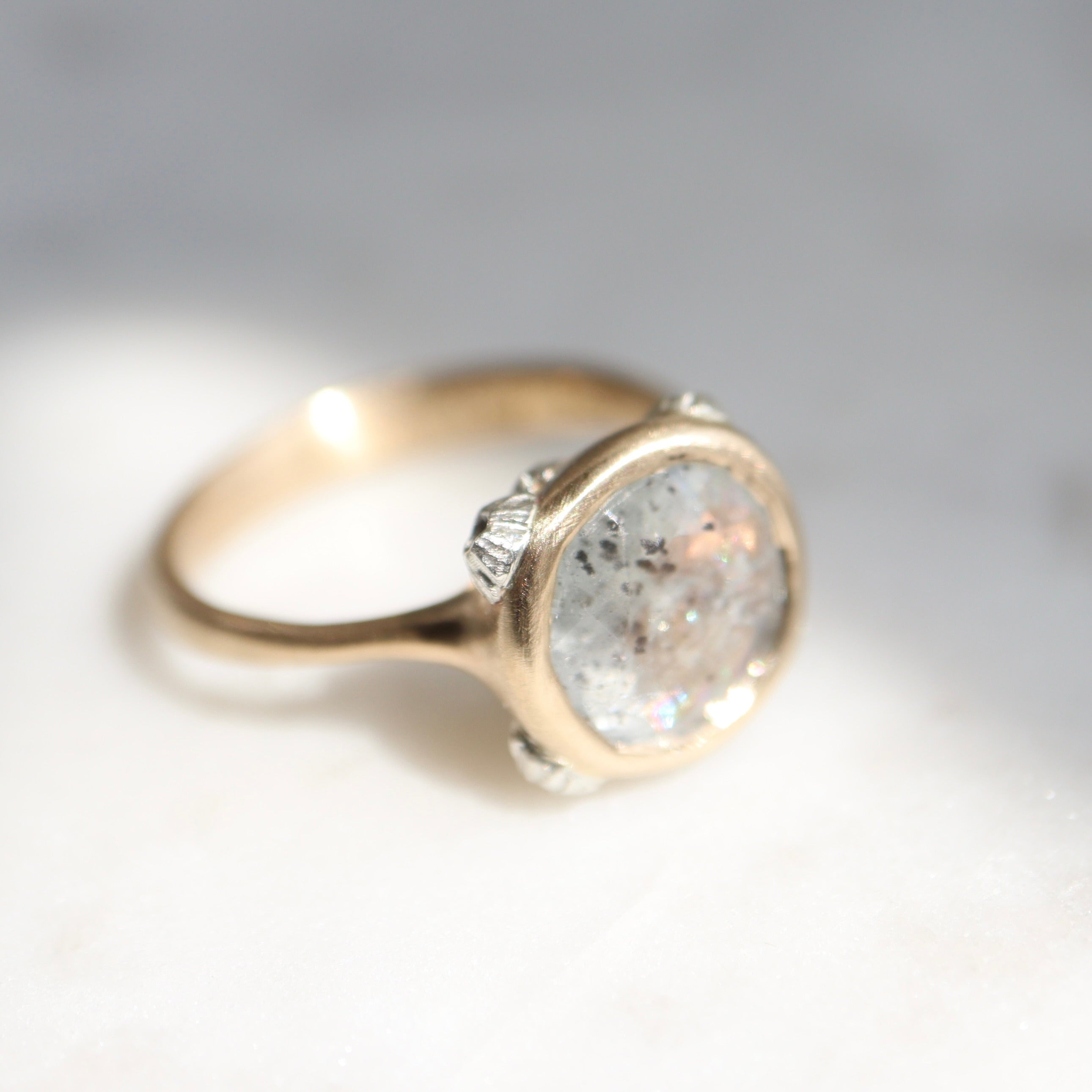 A 2.1ct Aquamarine ring with black inclusions set in a 10k gold band encrusted with silver barnacles. 