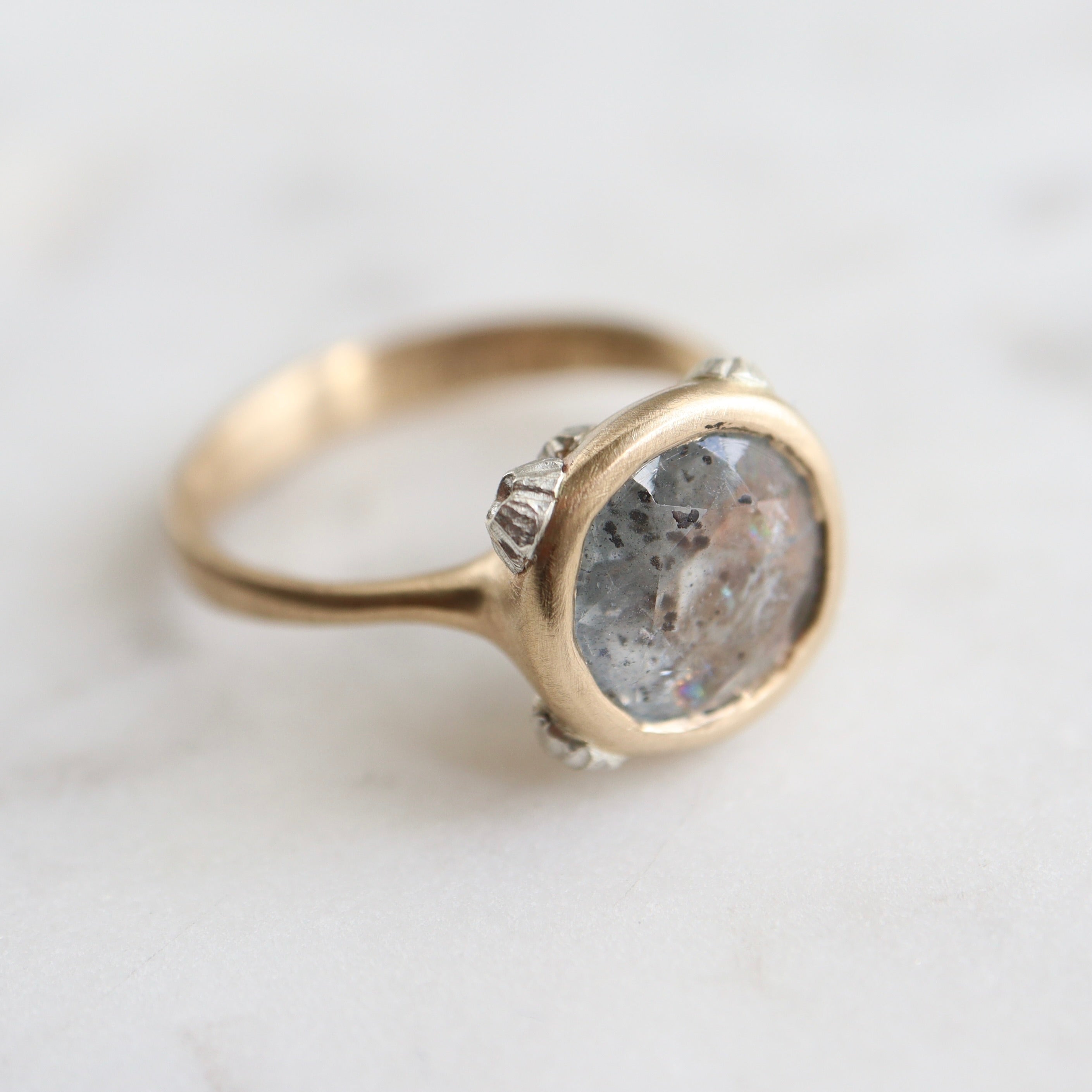 A 2.1ct Aquamarine ring with black inclusions set in a 10k gold band encrusted with silver barnacles. 