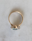Gold ring with a gemstone on a light gray background