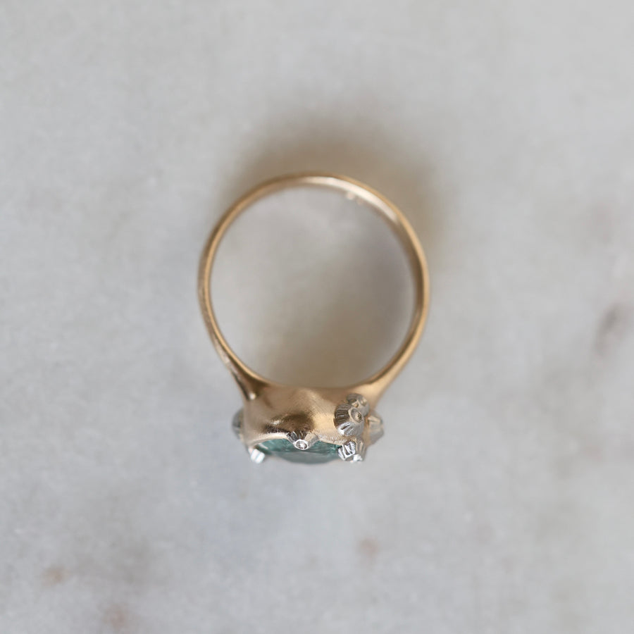 Gold ring with a gemstone on a light gray background