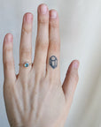 Hand with a ring and tattoo on a plain background