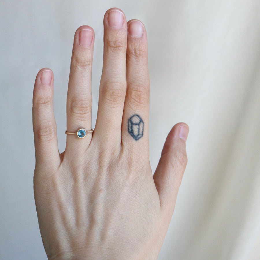Hand with a ring and tattoo on a plain background