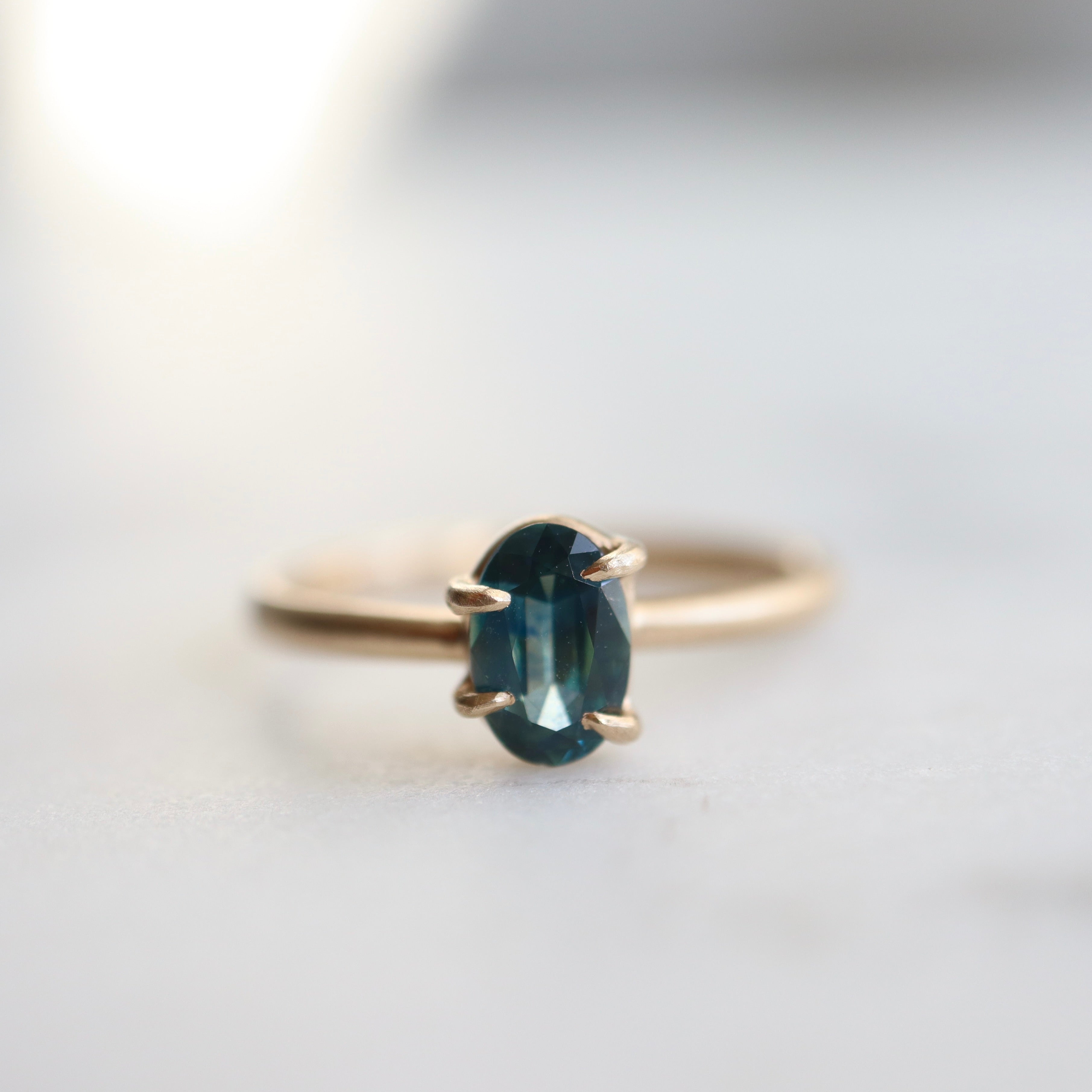 0.66ct Montana Sapphire Vanity Ring set in 14k gold with four prongs. The stone is an ocean blue. 