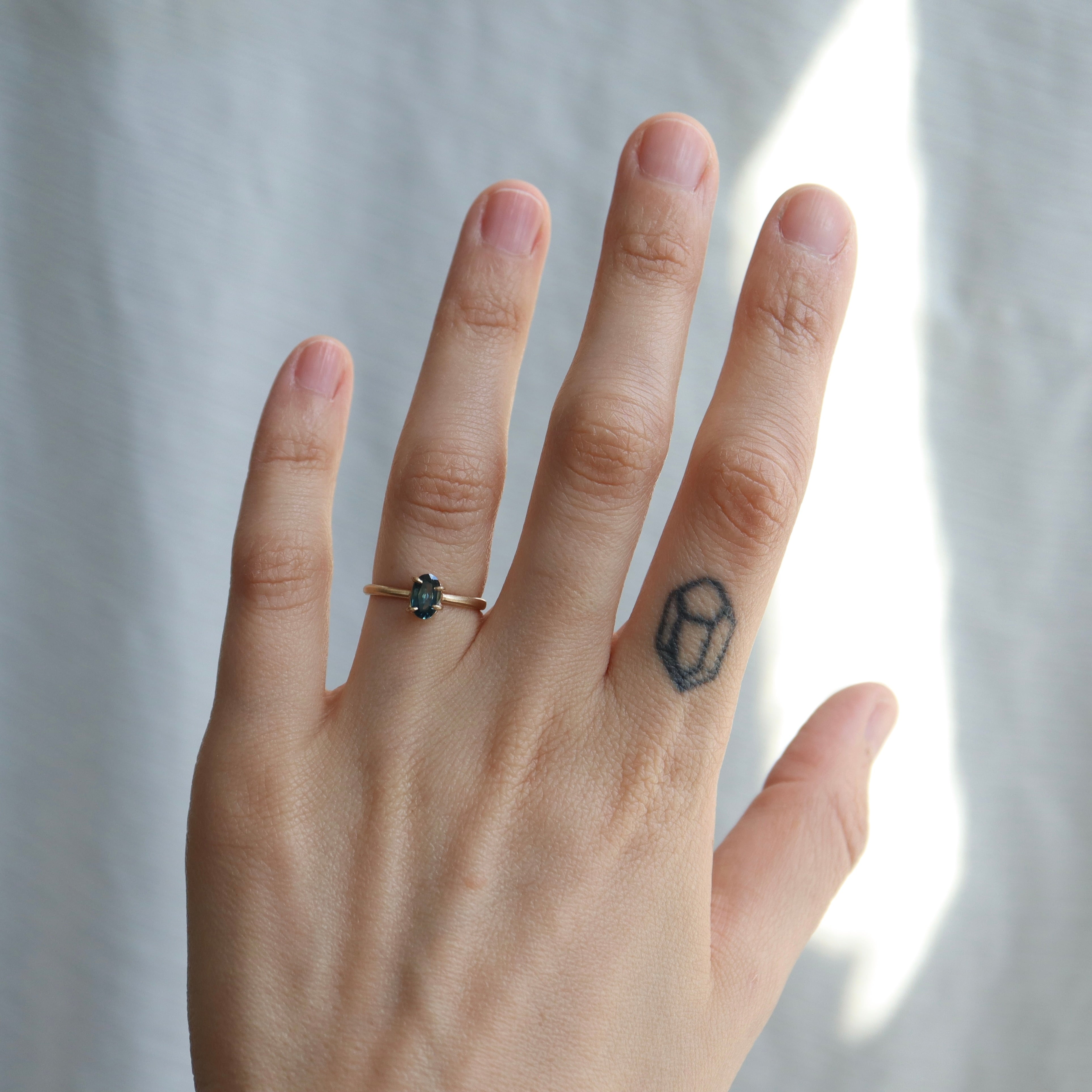 0.66ct Montana Sapphire Vanity Ring set in 14k gold with four prongs, displayed on a hand. 